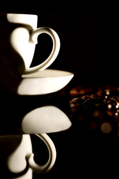 Kaffeetasse mit Herzschatten und Kaffeebohnen