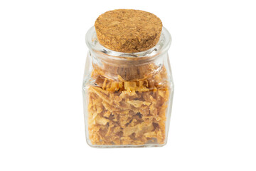 Crispy carmelized fried onion flakes in a glass jar isolated on white background. Spices and food ingredients.