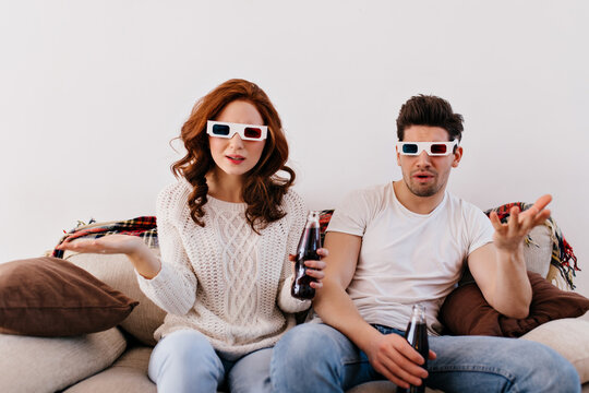 Couple posing emotionally while watching 3d film. Boy and girl spending valentine's day at home.