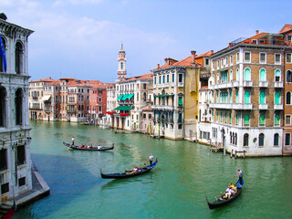 Fototapeta na wymiar Venice canal with three gondolas and buildings overlooking the water.