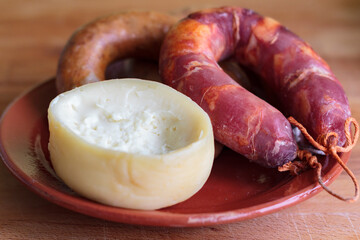 Sheep's milk cheese from Azeitao and portuguese smoked sausage on clay plate