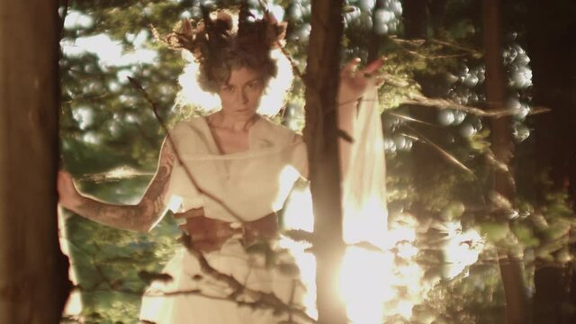 Woman Dressed In Headdress Dancing In Sunlit Forest