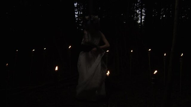 Woman Dressed As Azazel In White Dress Dancing In Dark