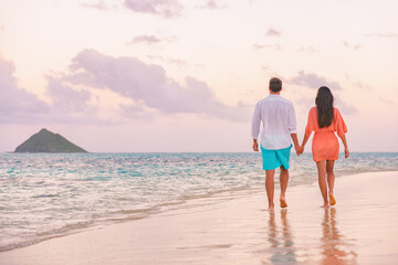 Couple beach vacation travel happy together romantic honeymoon in Lanikai, Oahu, Hawaii. Woman in dress, man wearing shirt. Beautiful sunset stroll lovers in love.