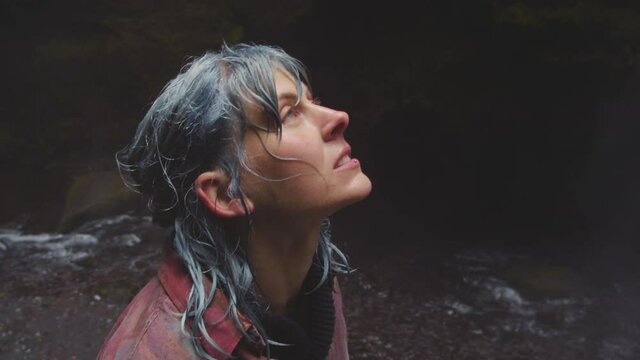 Blue Haired Woman Looking Up At Waterfall