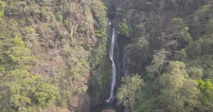 Water Falling From Height And Splashing Over Rocks At Mainapi Waterfall, Netravali Wildlife Sanctuary, South Goa, India. - Aerial Drone Shot