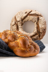 Wheat bread, pigtailed, sprinkled with sesame seeds, poppy seeds, lies on an indigo napkin, in the...