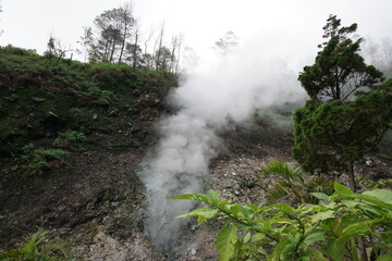 Fototapeta na wymiar A view of white smoke coming out of one of the craters in the Gedong Songo Temple area, near a hot spring. With a natural background