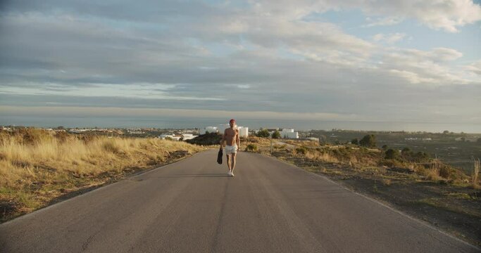 Shirtless Man In Shorts Walking Empty Road
