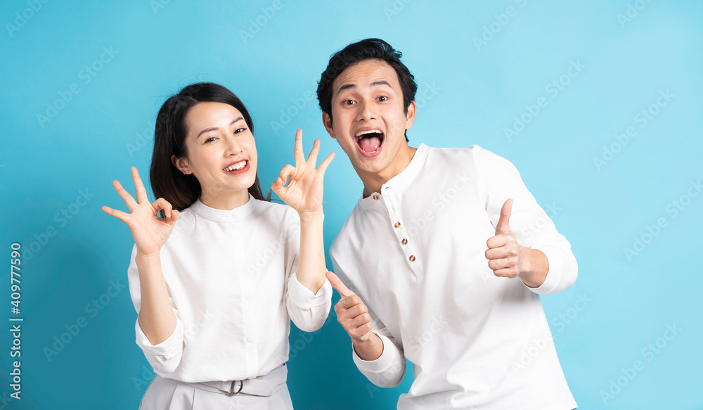 Wall mural portrait of young couple standing posing on blue background