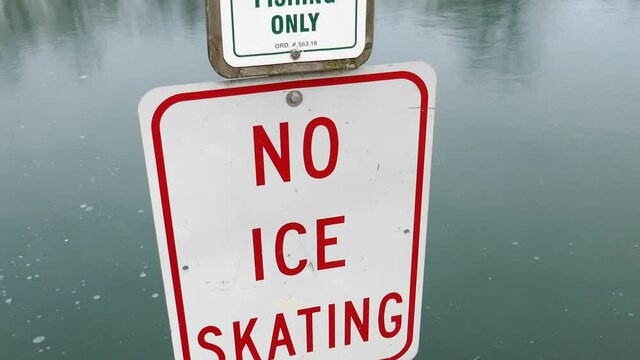 No Ice Skating sign surrounded by ice on frozen lake