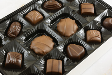 Close up of candy box of assorted Valentine's Day Chocolates on white marble table