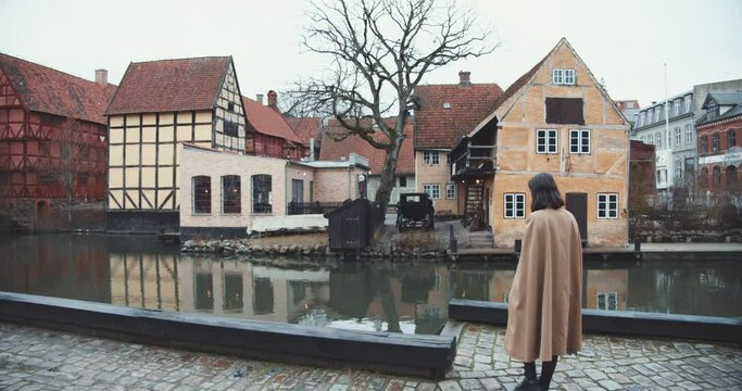 Woman In Long Coat Walking In Old Town Aarhus
