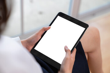 Mock up of woman hand holding digital tablet and touching blank screen