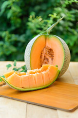 Closeup to Fresh juicy orange melon on wood plate