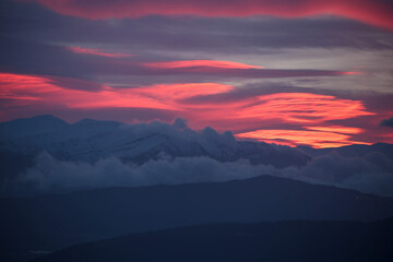 Fototapeta na wymiar pink red clouds in sunrise mountain mitsikeli in winter moring ioannina greece