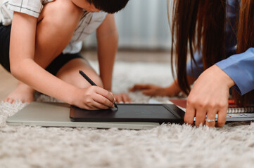 Asian family togetherness at home. Mom teaching kid for online learning education. New normal...
