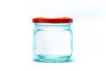 Empty glass jar and red lid isolated on white background.