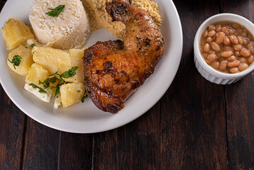 Sobrecoxa de frango assada com batatas soutê, arroz e farofa