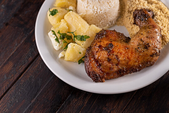 Sobrecoxa de frango assada com batatas sout&ecirc;, arroz e farofa