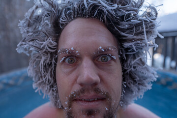Close up of man frosty, frozen hair with icicles hanging down from tips. Taken in winter in...