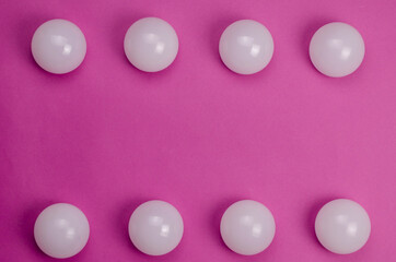 Creative geometric composition with white spheres on a pink background.