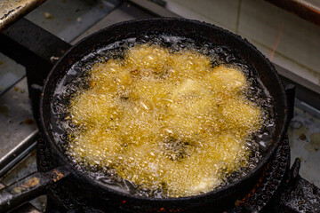 
freír el primer plano de los alimentos, cocinar pollo, aceite hirviendo comida caliente, cocina sucia, sartén negra.