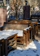 An empty street cafe covered with snow.
