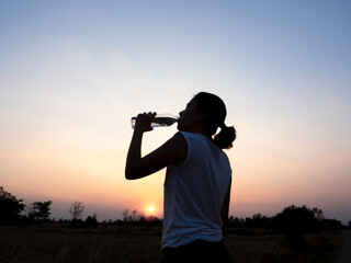 Asian woman drinking water after exercise.