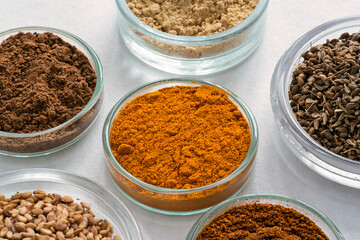 Assortment of different spices in small glass jars
