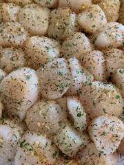 seasoned scallops ready to fry on a pan