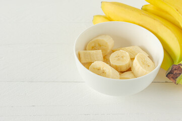 Ripe bananas cut in white bowl for eating. Healthy snack or breakfast concept