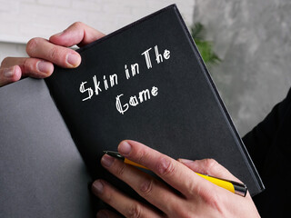  Financial concept meaning Skin in The Game with sign on the page.