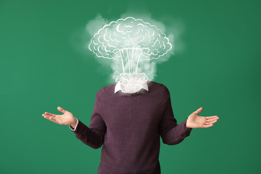 Young man with atomic bomb explosion instead of head on color background