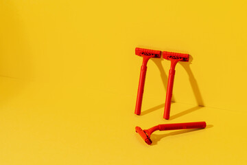 Disposable razors on yellow background, studio shot