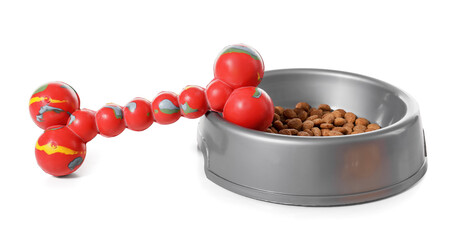 Bowl with dry pet food and toy on white background