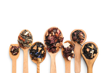 Spoons with different types of dry fruit tea on white background