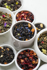 Bowls with dry fruit tea on light background