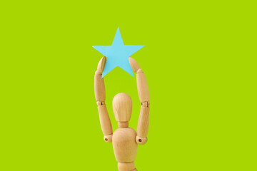 Wooden mannequin with star on color background