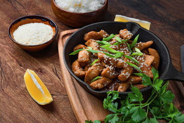  Teriyaki chicken breast in frying pan with rice and sesame seeds top view, traditional asian food