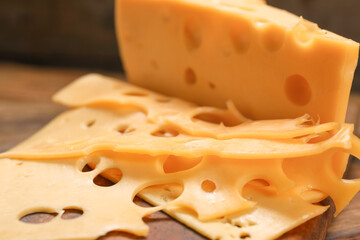 Piece of tasty cheese on wooden background, closeup