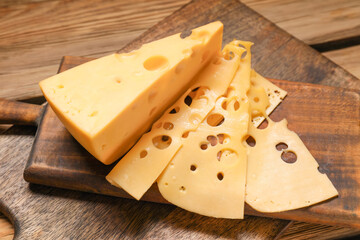 Pieces of tasty cheese on wooden background
