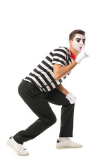 Male pantomimist showing silence gesture on white background