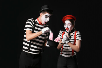 Male and female pantomimists on dark background