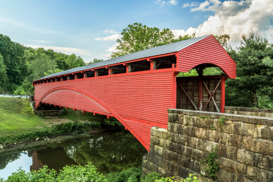 Built in 1853, the historic red Barrackville Covered Bridge crosses Buffalo Creek in Marion County, West Virginia not far from the city of Fairmont.