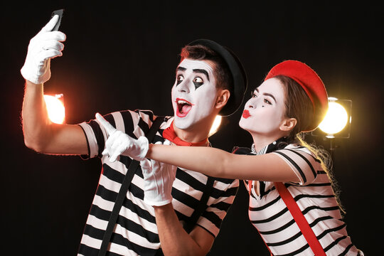 Male and female pantomimists on dark background