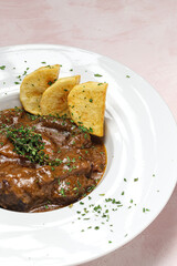 Homemade stew of osso buco meat with aromatic herb sauce