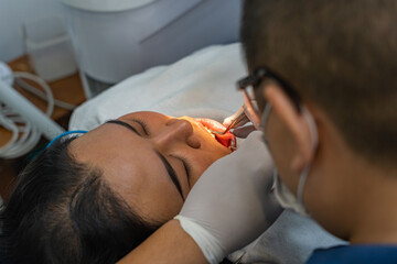 Rear view photo of dentist checking up front teeth for client