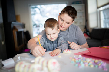 Fototapeta premium sister helping brother's write valentine's day notes