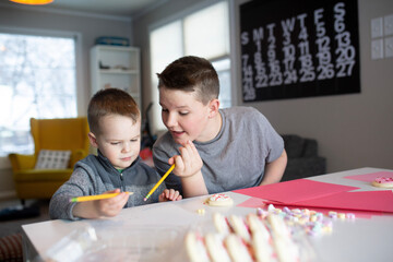 sister helping brother's write valentine's day notes